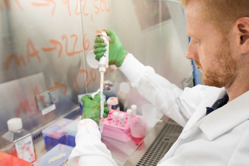 A researchers precisely measures a fluid. 